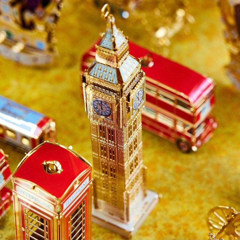 Exquisite handcrafted Big Ben Christmas ornament by The London Christmas Company, featuring intricate 24K gold detailing, displayed alongside iconic London double-decker bus and London Phone booth ornaments. Perfect for adding British charm to holiday decor.